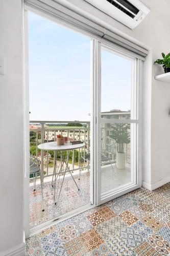 a room with a sliding glass door with a table at Hyllia by J&J Homes At Amani Grand Resort Residences Near Airport in Pusok