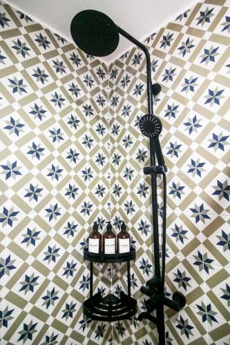 a lamp on a tiled floor with three candles on a shelf at Hyllia by J&J Homes At Amani Grand Resort Residences Near Airport in Pusok