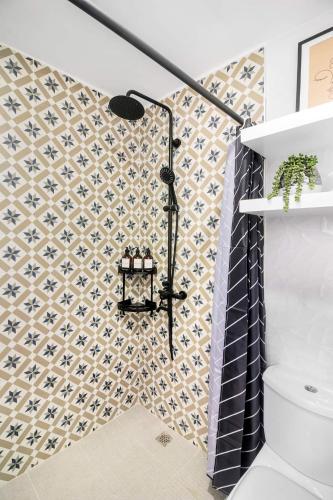 a bathroom with a shower with a wall at Hyllia by J&J Homes At Amani Grand Resort Residences Near Airport in Pusok