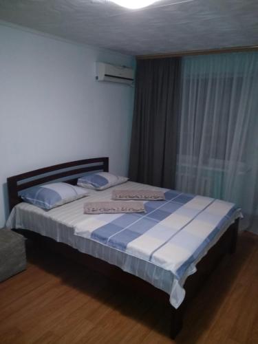a bedroom with a large bed with blue and white sheets at Центр 95 квартала, Смарт-TV in Kryvyi Rih