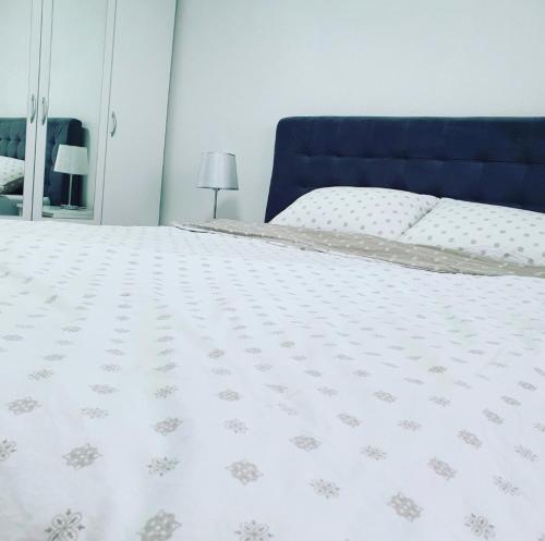 a bedroom with a bed with a blue head board at XENA apartment Gradiška in Bosanska Gradiška