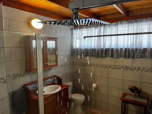 a bathroom with a sink and a toilet and a mirror at Six Second Avenue in Parys