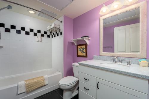 a bathroom with a sink toilet and a mirror at Harbour House at the Inn 314 in Fort Myers Beach