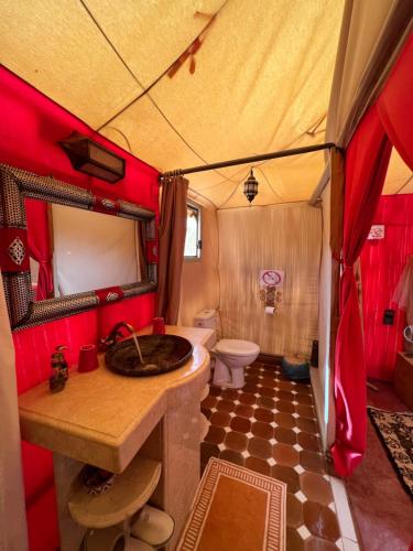 un bagno con lavandino e servizi igienici in una tenda. di Luxury traditional Tent Camp a Merzouga