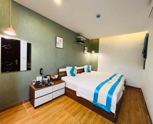 a bedroom with a bed and a desk in it at FLORA Hotel Phu Quoc in Phu Quoc
