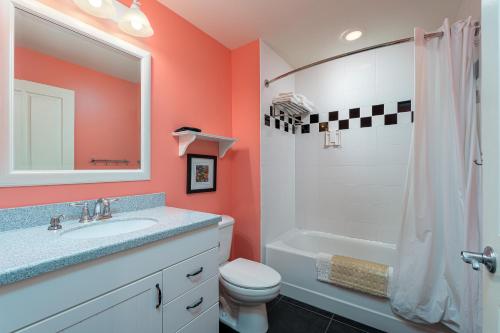 a bathroom with a sink and a toilet and a shower at Harbour House at the Inn 215 in Fort Myers Beach