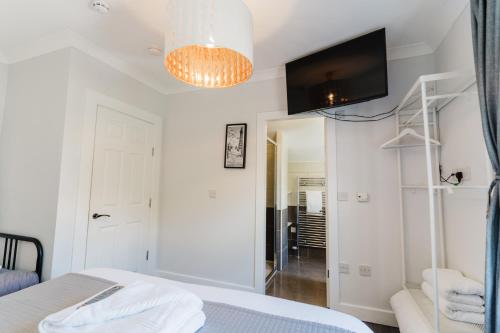 um quarto com uma cama e uma televisão na parede em Sweet Suites Lytham em Lytham St Annes