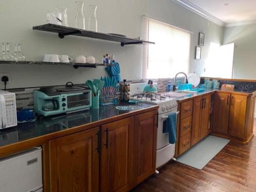 a kitchen with a sink and a stove top oven at Arcadia Studio Apartment in Augier