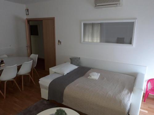 a bedroom with a bed and a table with chairs at Marys Home Apartment Međugorje in Međugorje