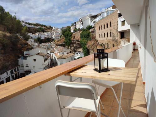 een balkon met een tafel en stoelen en uitzicht bij La Rosa Gris in Setenil