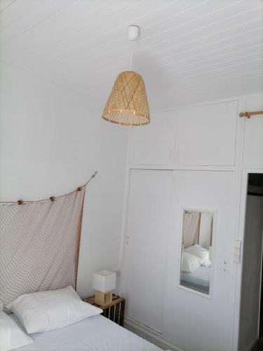 um quarto com uma cama, um candeeiro e um espelho em Maison de pecheur cour privée en centre ville em Saint-Gilles-Croix-de-Vie