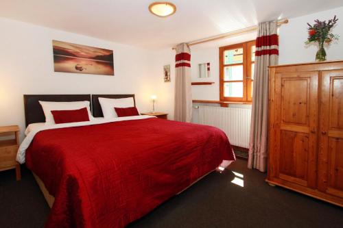 a bedroom with a large red bed and a window at Chalet Ruby in Les Deux Alpes