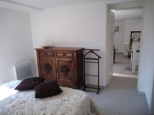 a bedroom with a wooden dresser and a bed at La Requeyrie in Montignac