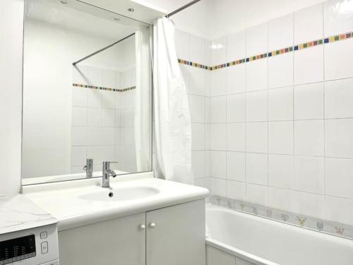 a white bathroom with a sink and a tub at Appartement • Paris/Disney • 1 Min Gare in Bussy-Saint-Georges