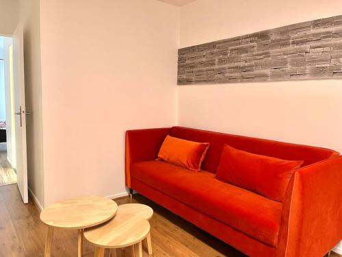 an orange couch in a living room with a table at Appartement • Paris/Disney • 1 Min Gare in Bussy-Saint-Georges