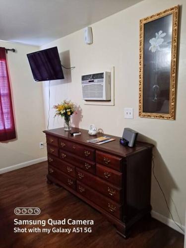 a dresser with a vase of flowers on top of it at Green house in Tampa
