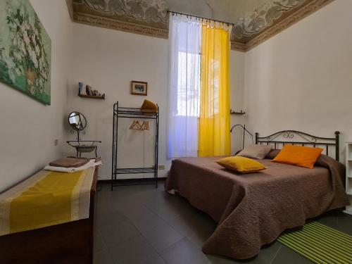 佩魯賈的住宿－Casa dei Gigli，一间卧室设有两张床,窗户配有黄色窗帘