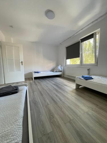 an empty room with two beds and a window at estrella24 LIVING ROOMS London in Herne