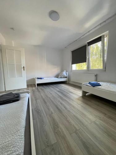 une chambre vide avec 2 lits et une fenêtre dans l'établissement estrella24 LIVING ROOMS London, à Herne