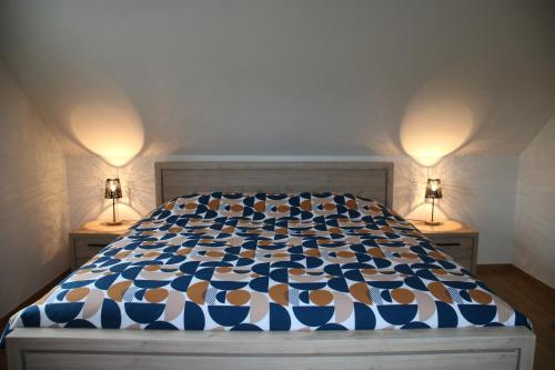 1 cama en un dormitorio con 2 lámparas en ambos lados en Charmante maison de campagne "Chemin Saint-Roch", 