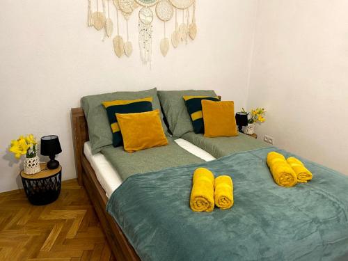 two twin beds in a bedroom with yellow pillows at Green House apartments in Krakow