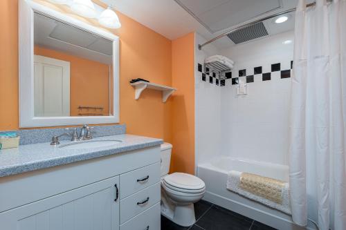 a bathroom with a sink and a toilet and a mirror at Harbour House at the Inn 310 in Fort Myers Beach