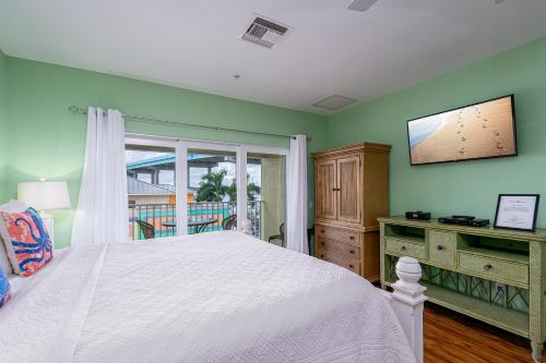 a bedroom with a white bed and a window at Harbour House at the Inn 310 in Fort Myers Beach