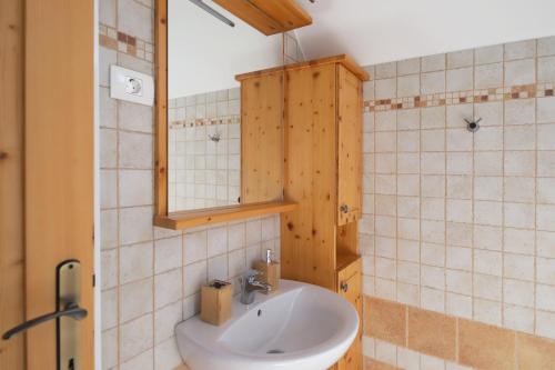 La salle de bains est pourvue d'un lavabo et d'un miroir. dans l'établissement Apartments pr' Špeli, à Bohinj