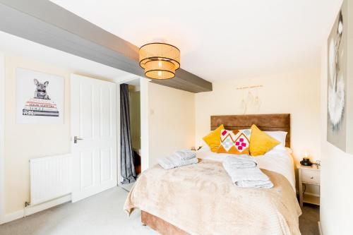 a bedroom with a large bed with yellow pillows at Why Not in Stow on the Wold
