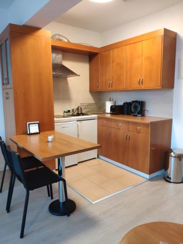 a kitchen with wooden cabinets and a wooden table at Ευ ζην Central / Ev zen central in Nicosia