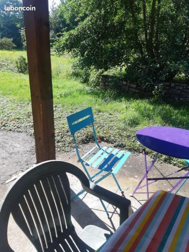 a table and a chair next to a table and a blue table and chairs at Gite Clé Vacances Courchaton in Courchaton