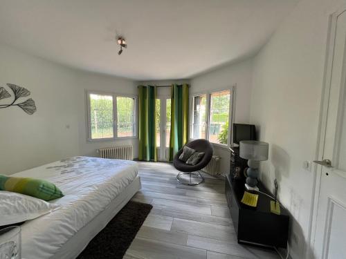 a bedroom with a bed and a chair in it at Chambre privée Chiberta in Chanas