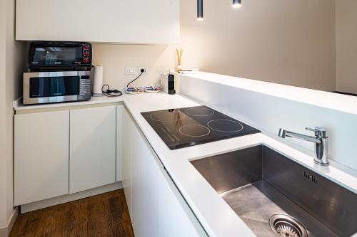 uma cozinha com um lavatório e um micro-ondas em Brera Livings, Charming flat near Duomo em Milão