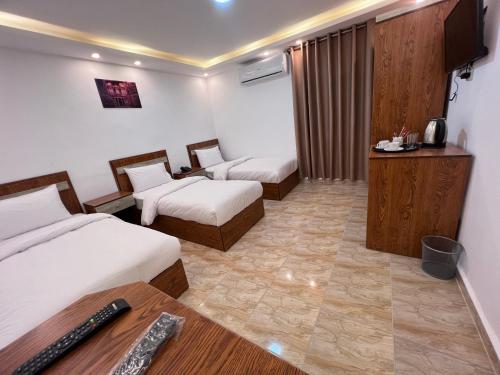 a hotel room with two beds and a television at Petra Family Hotel in Wadi Musa