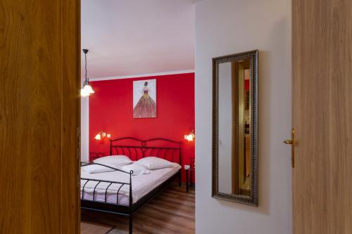 a red bedroom with a bed and a mirror at Apartment Red Romantic 2-1 in Bale