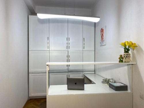 a white room with a desk with a laptop on it at Green House apartments in Krakow