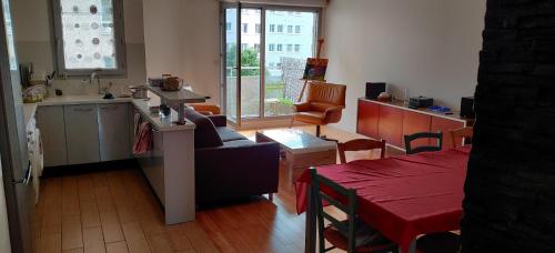 Il comprend un salon avec un canapé, une cuisine et une table. dans l'établissement Chambre chez l'habitant a 5 minutes du métro, à Ivry-sur-Seine