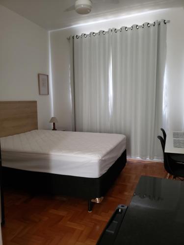 ein Schlafzimmer mit einem Bett und einem Schreibtisch darin in der Unterkunft Studio em Teresópolis no bairro Alto, próximo principais pontos turísticos in Teresópolis