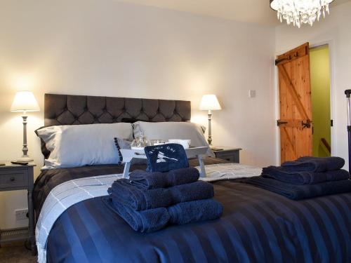 a bedroom with a large bed with blue towels on it at Gavels Gap in Nantwich