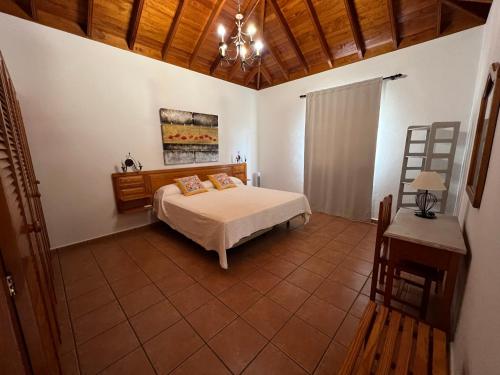 1 dormitorio con cama y lámpara de araña en Casa Agustín, en Los Llanos de Aridane