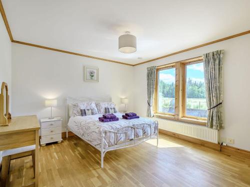 a bedroom with a bed with purple pillows on it at Benmore Drimfern - Uk38742 in Benmore