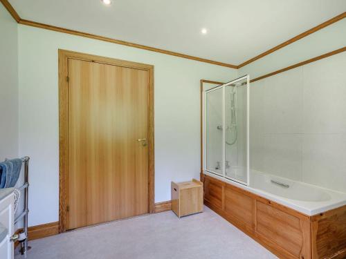 a bathroom with a tub and a glass shower at Benmore Drimfern - Uk38742 in Benmore