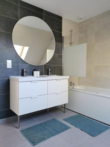 une salle de bain avec un lavabo, un miroir et une baignoire dans l'établissement Maison cosy entre Paris Rouen et Deauville, à Pont-de-lʼArche