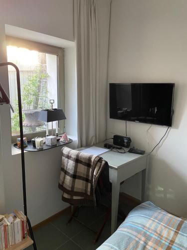 - une chambre avec un bureau, une télévision et un lit dans l'établissement Suite privée avec accès jardin en coeur de village, à Guerville