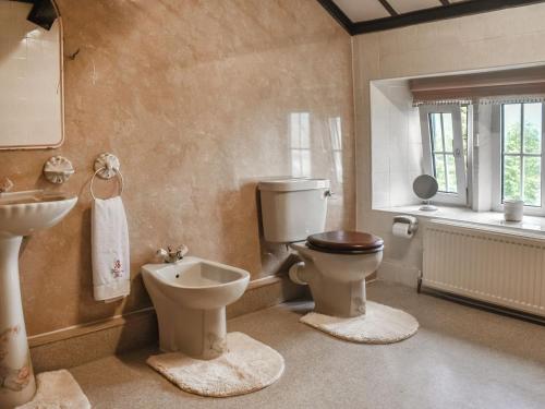 a bathroom with a toilet and a sink at Foxstones Farm House in Worsthorne