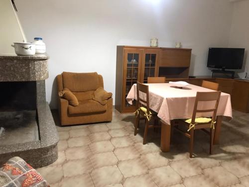 ein Wohnzimmer mit einem Tisch und einem Stuhl in der Unterkunft Appartamento luminoso e spazioso al primo piano in Capoterra