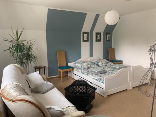 een slaapkamer met een bed en een bank bij Ruhiges Zimmer nahe Therme & Kurpark in Bad Steben