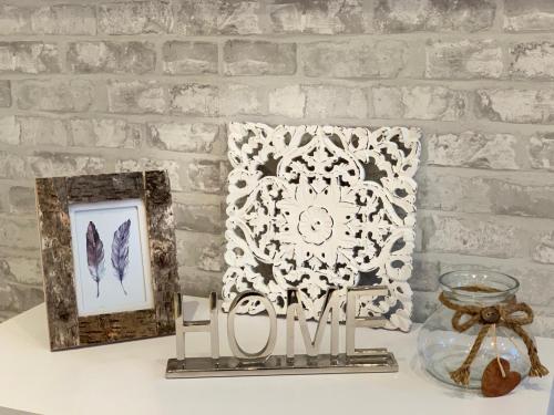 a table with two pictures and a clock on a brick wall at Apartamentos Nenufar in Alhama de Aragón