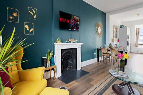a living room with a yellow couch and a fireplace at Modern 1 Bed Apartment, Sea Views, free parking, wifi, netflix in Teignmouth