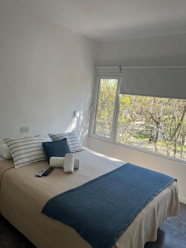 1 dormitorio con 1 cama grande y ventana en Valeria City en Valeria del Mar
